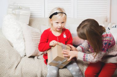 Sihirli hediye kutusu ve küçük bir kız bebek, Noel mucizesi, küçük mutlu, mutlu bir kız hediyelerle dolu bir kutuyu açıyor.