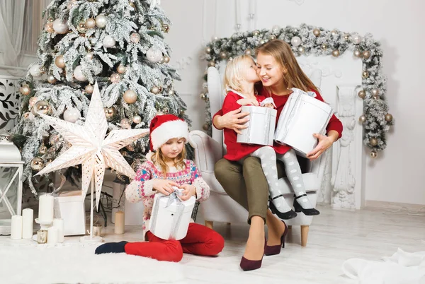 Anne ve çocukları Noel ağacının yanında kutluyorlar.