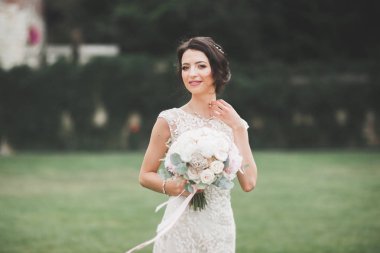 Parkta poz veren zarif beyaz elbiseli güzel gelin.