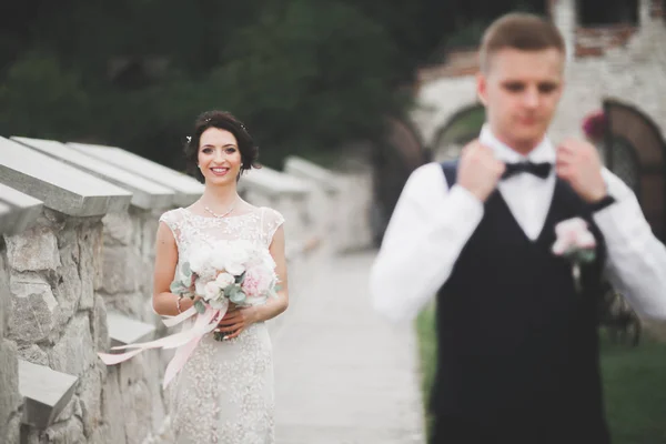 Preciosa pareja feliz boda, novia con vestido blanco largo posando en la hermosa ciudad —  Fotos de Stock