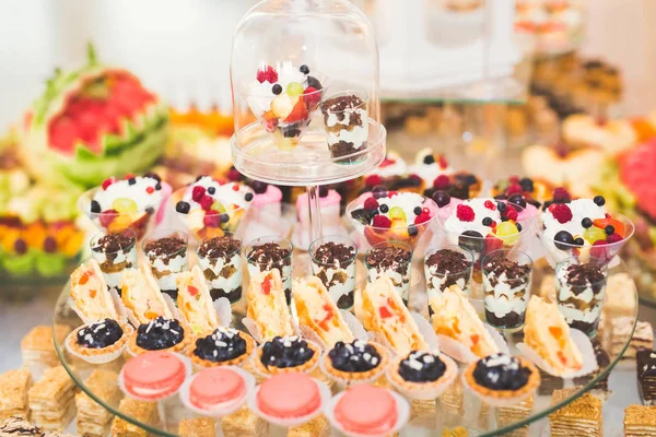 Deliciosos dulces en el buffet de dulces de boda con postres, cupcakes — Foto de Stock