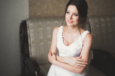 Beyaz elbiseli lüks gelin düğün törenine hazırlanırken poz veriyor.