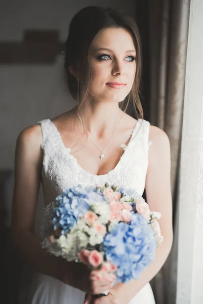 Novia de lujo en vestido blanco posando mientras se prepara para la ceremonia de boda — Foto de Stock