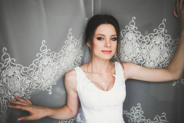 Belle mariée portant une robe de mariée de mode avec des plumes avec luxe délice maquillage et coiffure, studio séance photo d'intérieur — Photo