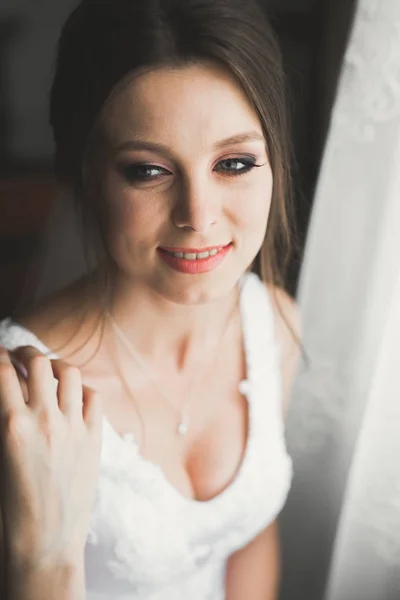 Πανέμορφη νύφη με ρόμπα ποζάρει και ετοιμάζεται για την γαμήλια τελετή πρόσωπο σε ένα δωμάτιο — Φωτογραφία Αρχείου
