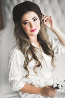 Cüppeli muhteşem gelin bir odada düğün töreni için poz veriyor ve hazırlanıyor.