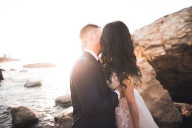 Güzel bir sahilde poz veren genç bir çiftin mutlu ve romantik sahnesi.