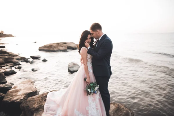 Feliz y romántica escena de recién casada joven pareja de boda posando en la hermosa playa — Foto de Stock