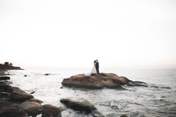 Счастливая и романтичная сцена молодоженов, позирующих на прекрасном пляже — стоковое фото