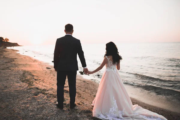 Glückliche und romantische Szene von frisch verheirateten jungen Hochzeitspaaren, die am schönen Strand posieren — Stockfoto