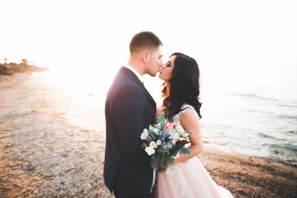 Scène heureuse et romantique de jeune couple marié posant sur une belle plage — Photo