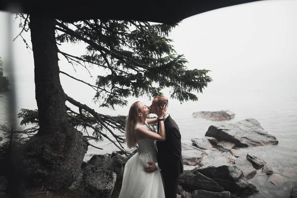 Gelukkig en romantisch tafereel van net getrouwd jong bruidspaar poserend op mooi strand — Stockfoto