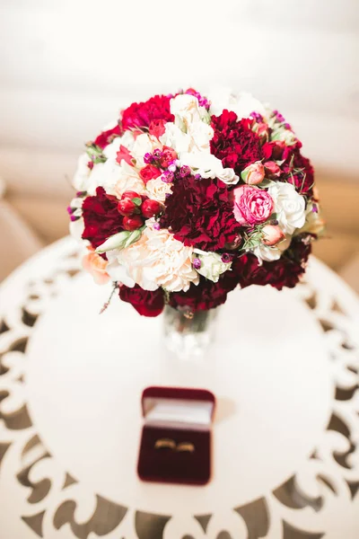 Hermosa imagen tonificada con anillos de boda sobre el fondo de un ramo de flores — Foto de Stock