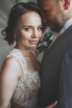 Güzel gelin ve damat düğün günlerinde kucaklaşıp öpüşürler.