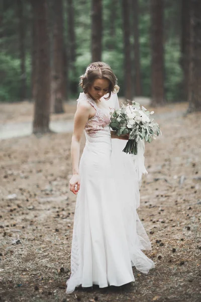 Krásná nevěsta pózuje ve svatebních šatech venku — Stock fotografie