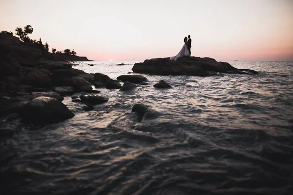 Feliz y romántica escena de recién casada joven pareja de boda posando en la hermosa playa — Foto de Stock