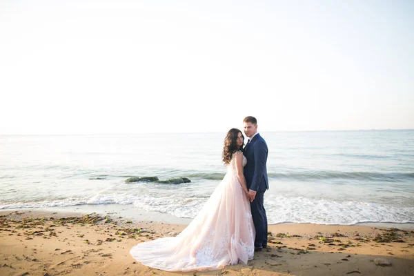 エレガントなスタイリッシュな幸せな結婚式のカップル、花嫁、海と空の背景に豪華な新郎 — ストック写真