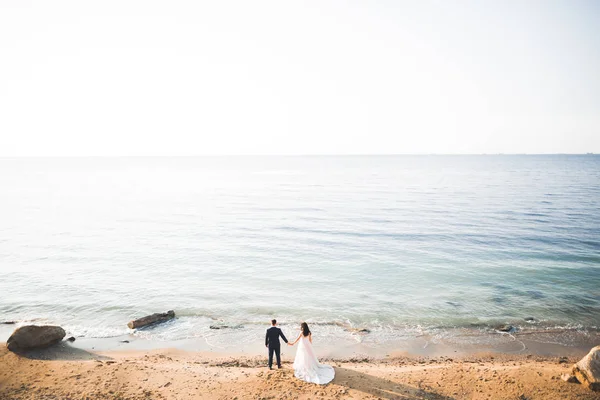 Scène heureuse et romantique de jeune couple marié posant sur une belle plage — Photo