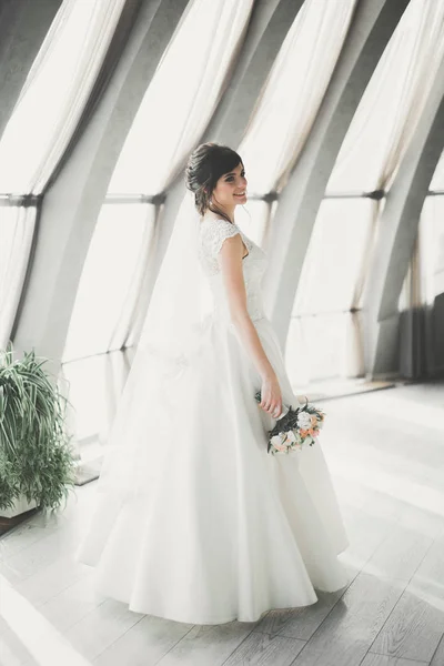 Retrato de novia impresionante con el pelo largo posando con gran ramo — Foto de Stock