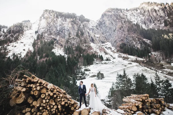 Hermosa pareja joven en las montañas de invierno. Paseo de invierno de los amantes. Hombre abrazando mujer —  Fotos de Stock