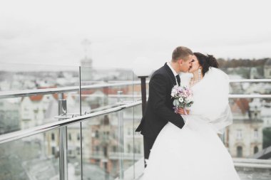 Güzel, mutlu bir düğün çifti, güzel şehirde uzun beyaz elbiseli bir gelin.