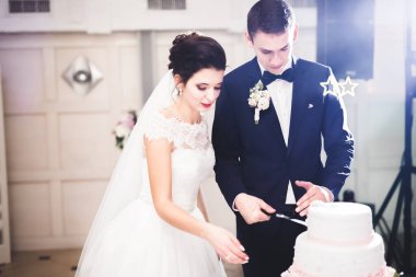 Gelin ve damat düğün pastasını kesiyor.