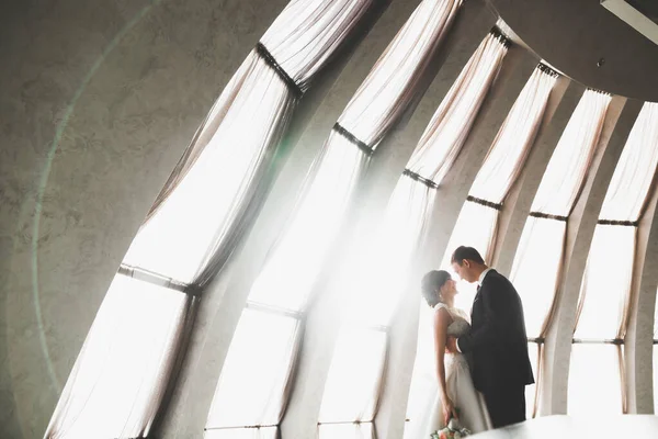 Lovely happy wedding couple, bride with long white dress posing in beautiful city — Stock Photo, Image