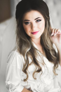 Beyaz elbiseli lüks gelin düğün törenine hazırlanırken poz veriyor.