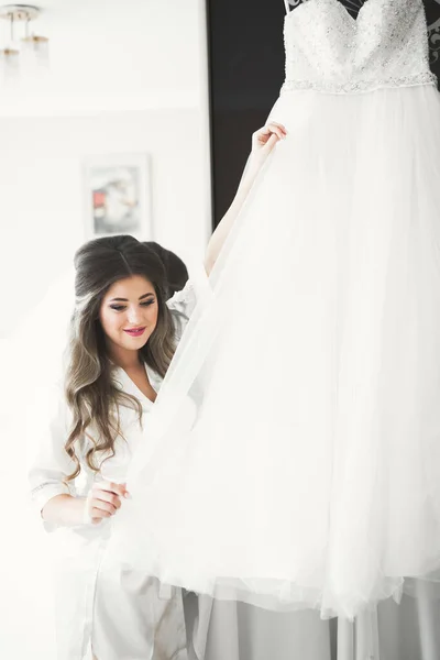 Noiva de luxo em vestido branco posando enquanto se prepara para a cerimônia de casamento — Fotografia de Stock