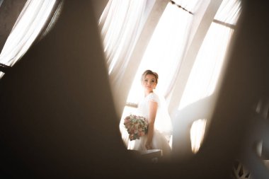 Gelin çiçekli büyük ve güzel bir düğün buketi tutuyor.