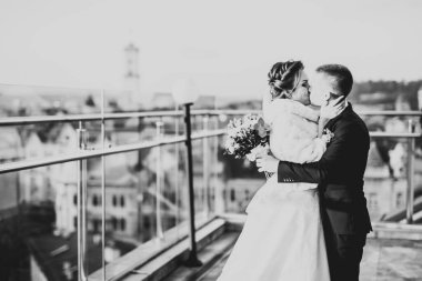 Güzel gelin ve damat düğün günlerinde kucaklaşıp öpüşürler.