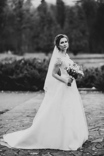 Retrato de novia impresionante con el pelo largo posando con gran ramo — Foto de Stock