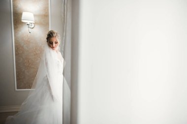 Beyaz elbiseli lüks gelin düğün törenine hazırlanırken poz veriyor.