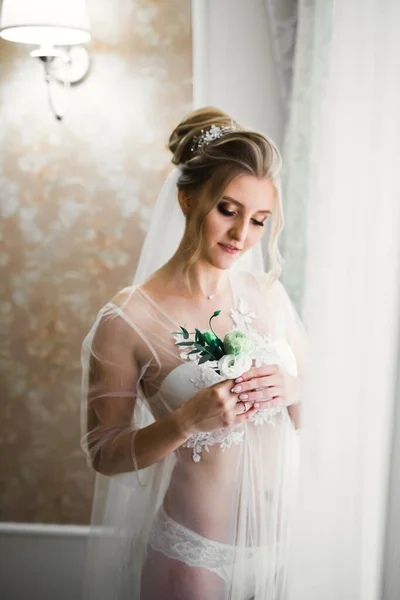 Luxe bruid in witte jurk poseren tijdens de voorbereiding voor de huwelijksceremonie — Stockfoto
