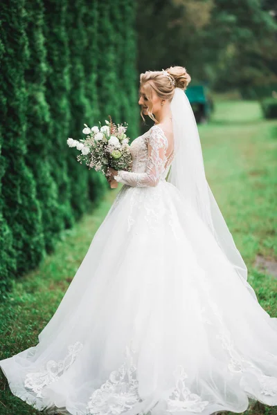 Retrato de belleza de la novia con vestido de novia de moda con plumas con maquillaje y peinado de lujo deleite — Foto de Stock