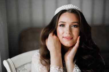 Cüppeli muhteşem gelin bir odada düğün töreni için poz veriyor ve hazırlanıyor.