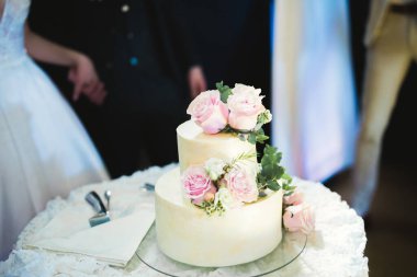 Masada süslü düğün pastası var.