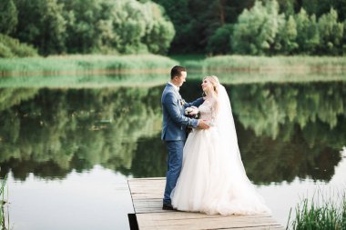 Romantik düğün anı, yeni evli çiftin gülümseyen portresi, gelin ve damadın kucaklaşması