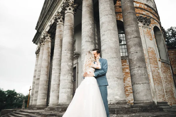 Beautiful bride and groom embracing and kissing on their wedding day outdoors — Stock Photo, Image