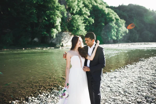 La pareja de boda en la naturaleza se está abrazando. Hermosa modelo chica en vestido blanco. Hombre de traje —  Fotos de Stock