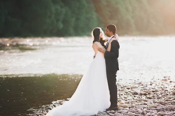 Boda pareja, novio y novia abrazos, al aire libre cerca del río — Foto de Stock