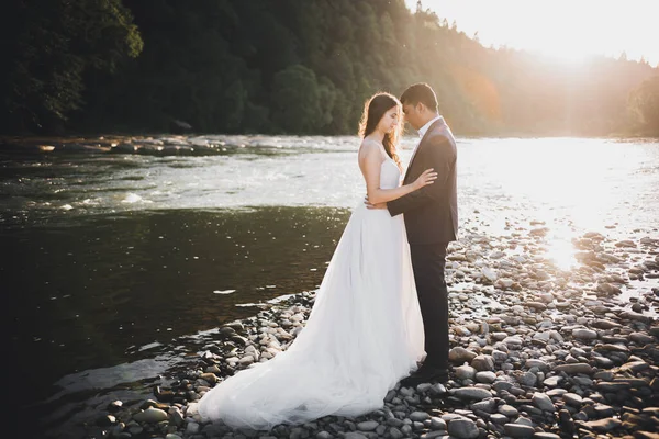 Esküvői pár, vőlegény és menyasszony ölelés, szabadban a folyó mellett — Stock Fotó