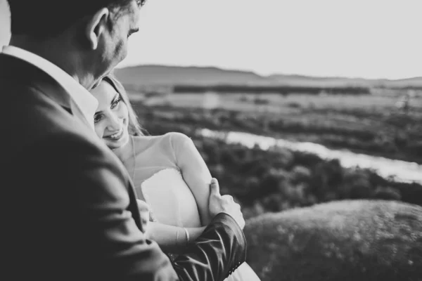 La coppia nuziale sulla natura si sta abbracciando. Bella ragazza modello in abito bianco. Uomo in completo — Foto Stock