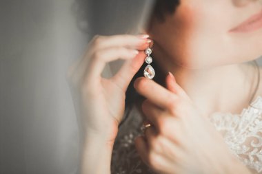 Cüppeli muhteşem gelin bir odada düğün töreni için poz veriyor ve hazırlanıyor.