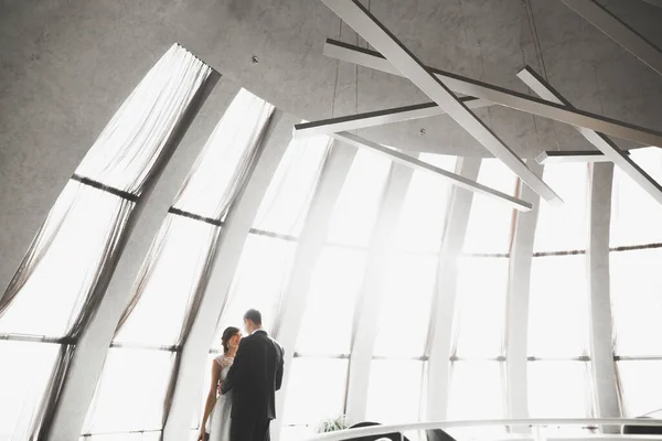 Lovely happy wedding couple, bride with long white dress posing in beautiful city — Stock Photo, Image