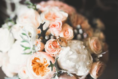 Çiçek buketinin arka planında alyanslar olan güzel renkli bir resim.