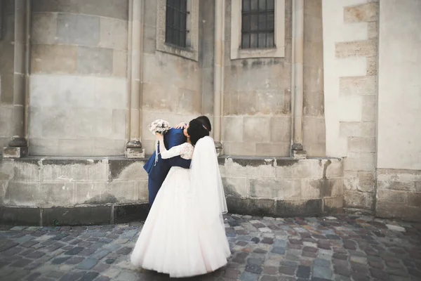 Preciosa pareja feliz boda, novia con vestido blanco largo posando en la hermosa ciudad —  Fotos de Stock