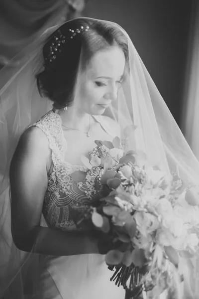 Preciosa novia en bata posando y preparándose para la ceremonia de boda cara en una habitación —  Fotos de Stock