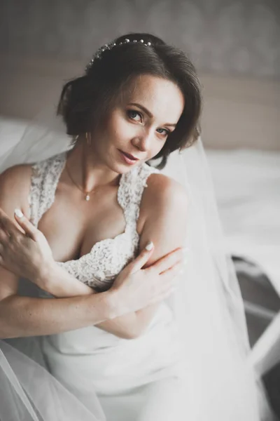 Linda noiva em roupão posando e se preparando para o rosto cerimônia de casamento em uma sala — Fotografia de Stock