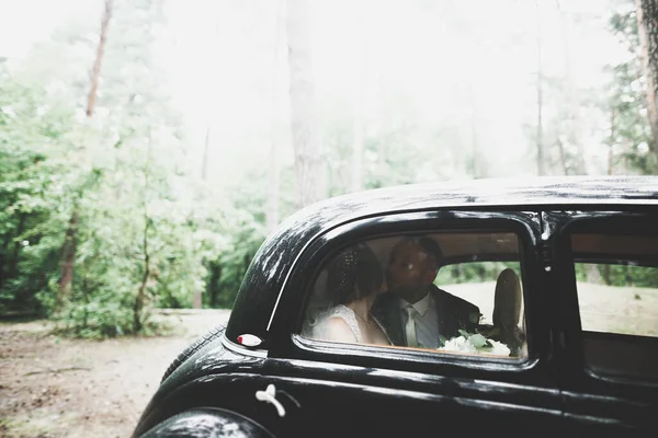 Pareja recién casada en el lujoso coche retro el día de su boda — Foto de Stock